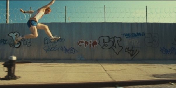 ari gold as power running in front of graffiti wall